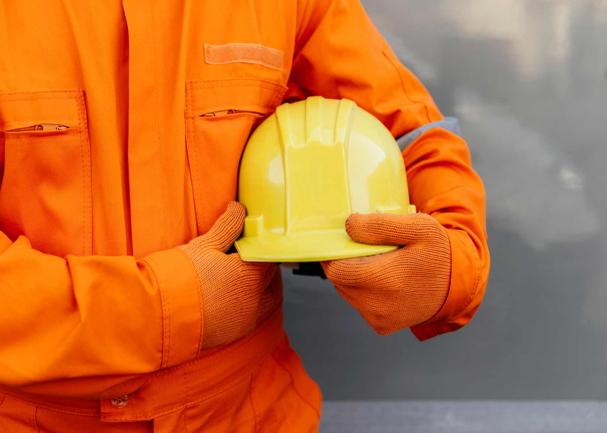 front view worker uniform holding hard hat 1